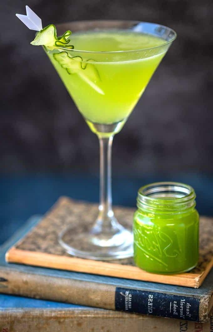 Martini τζιν με αγγούρι σε ποτήρι Martini ισορροπημένο πάνω σε στοίβα βιβλίων