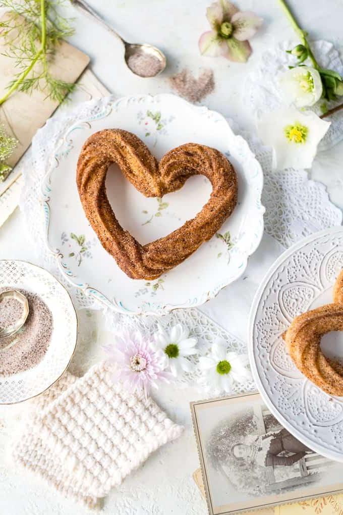 Churros σε σχήμα καρδιάς σε ένα πιάτο, φωτογραφημένα από πάνω