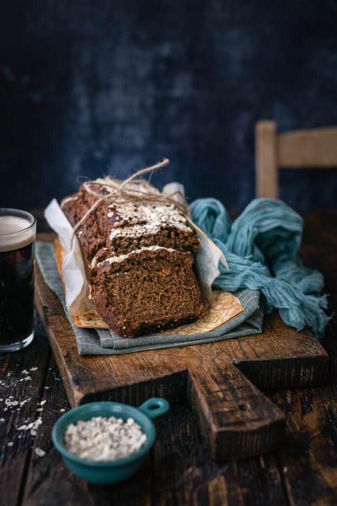 Ψωμί Γκίνες 7 Ιρλανδικό ψωμί Guinness, κομμένο σε φέτες, πάνω σε ξύλινη επιφάνεια με ένα ποτήρι Guinness δίπλα