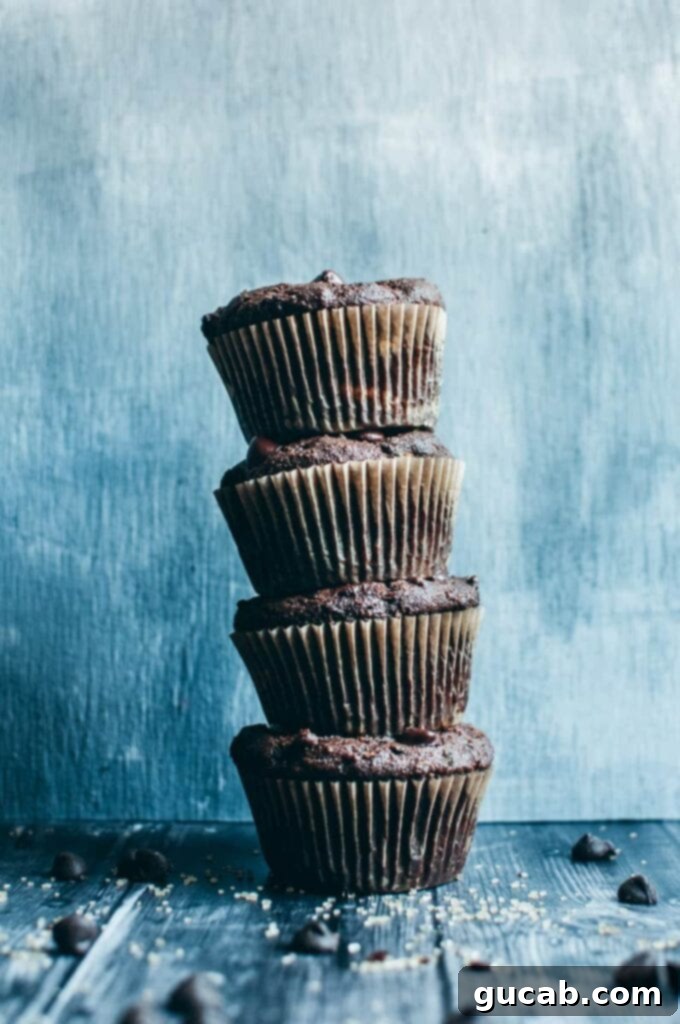 15 Decadent Cacao Delights 12 a stack of freshly baked healthy chocolate zucchini muffins, showcasing their tempting dark color and moist texture