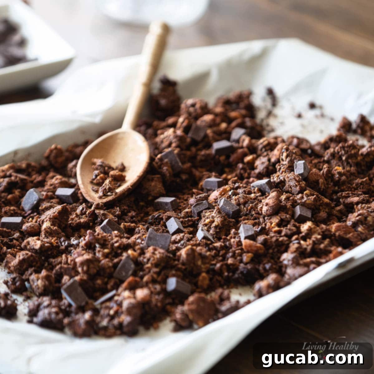 15 Decadent Cacao Delights 14 homemade dark chocolate granola spread on a sheet pan, showing its rich clusters and crispy texture