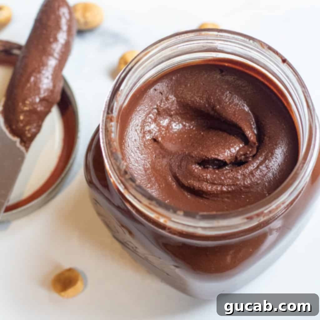 15 Decadent Cacao Delights 4 a jar of freshly made homemade Nutella, with a spoon dipping into its creamy, rich texture