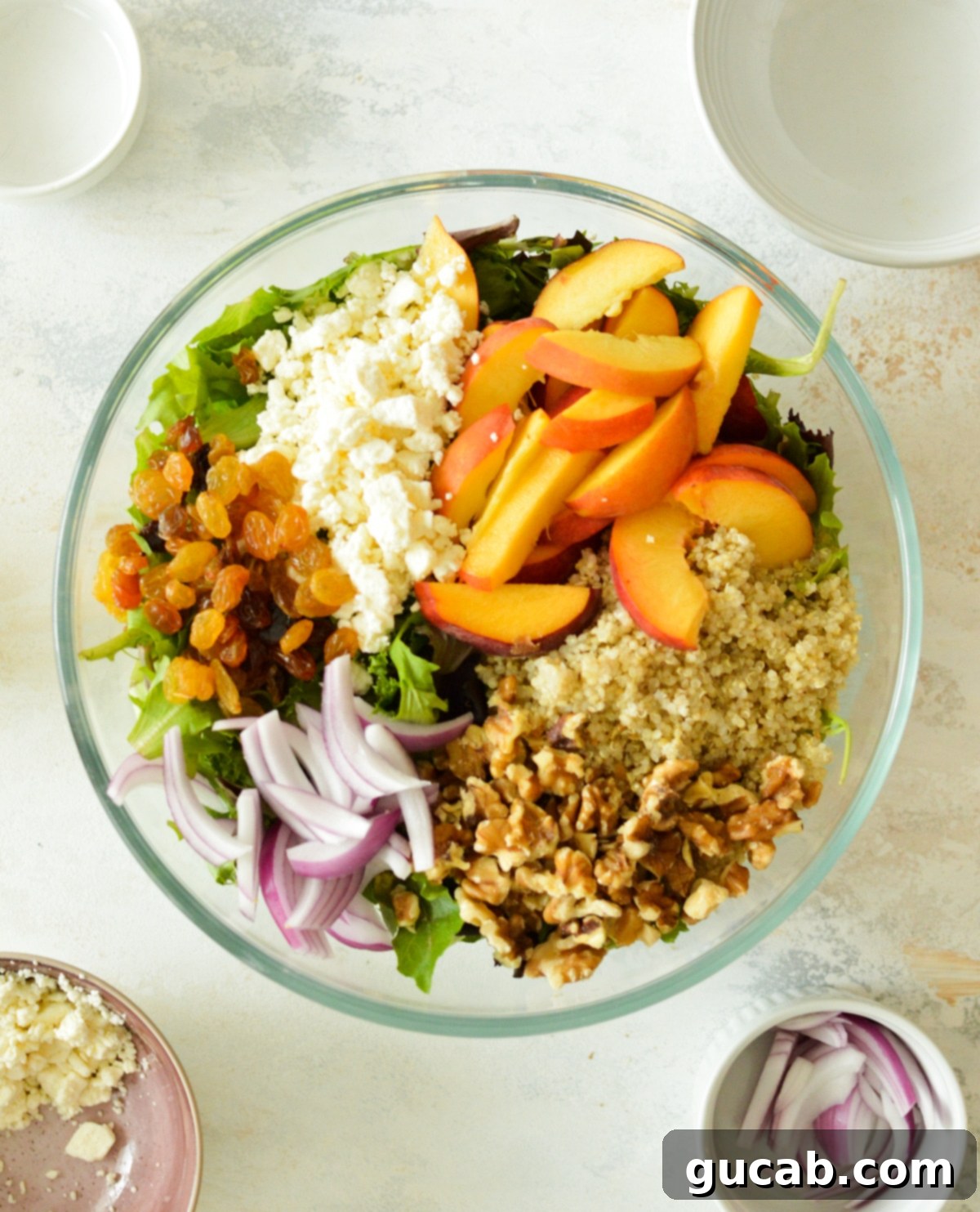 Peachy Feta Quinoa Salad 2 A colorful Quinoa Salad with Feta, Peaches, Raisins, and Red Onions on mixed greens, drizzled with citrus vinaigrette, perfect for a healthy summer meal.