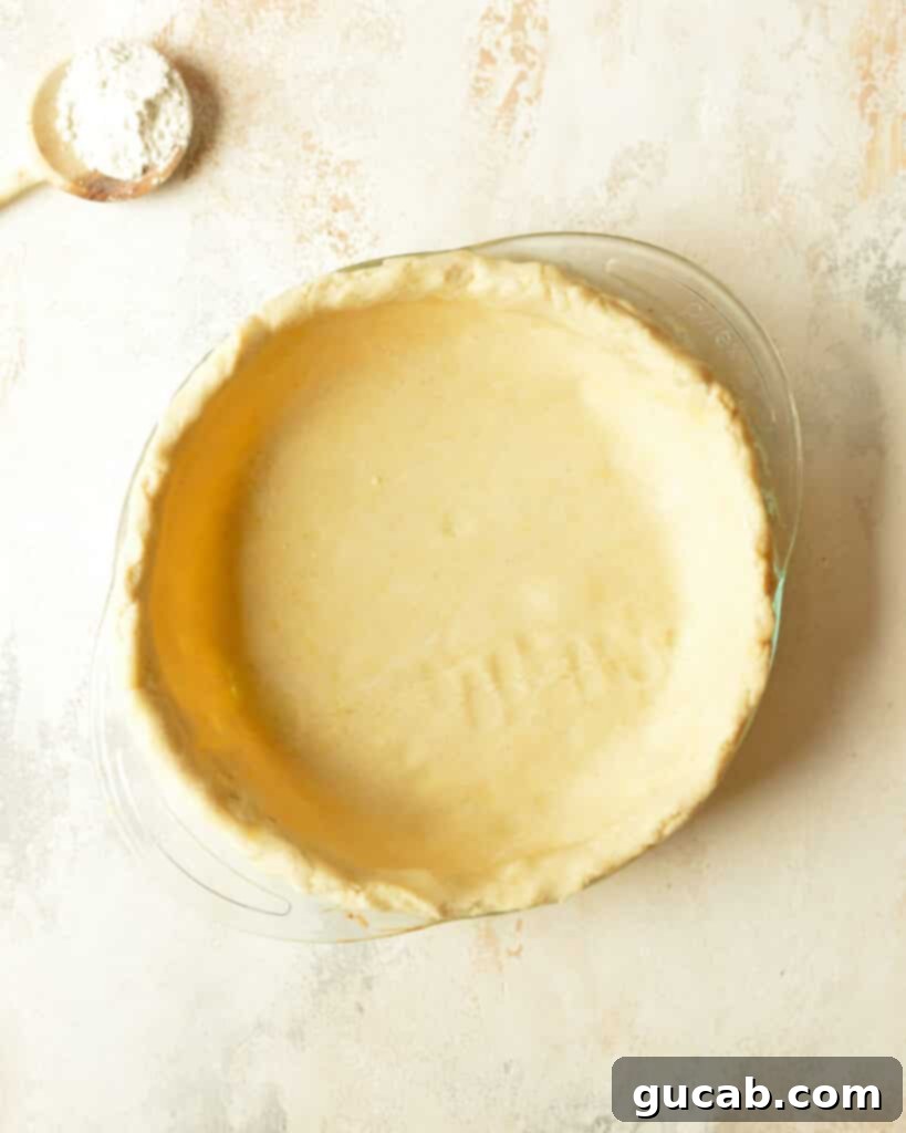 Close-up of trimmed pie dough edge with an inch of overhang for crimping.