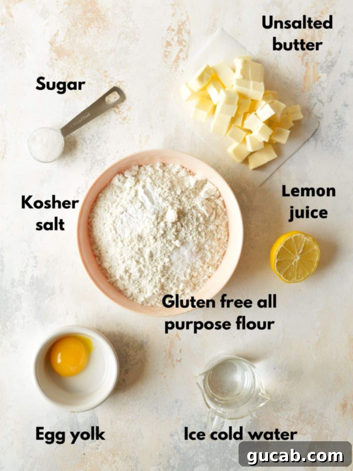 A selection of ingredients for gluten-free pie crust including flour, butter, sugar, and lemon.