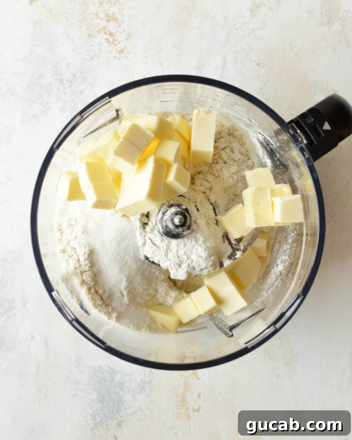 Gluten-free flour, sugar, and salt being pulsed in a food processor.