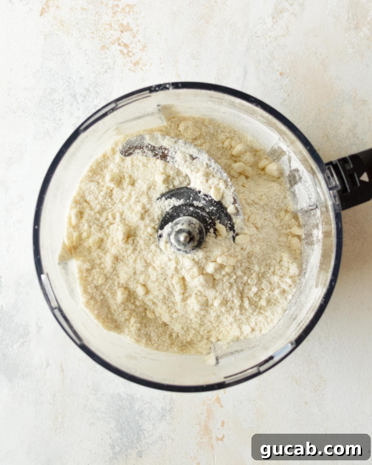Cold butter chunks blended with flour, sugar, and salt in a food processor.