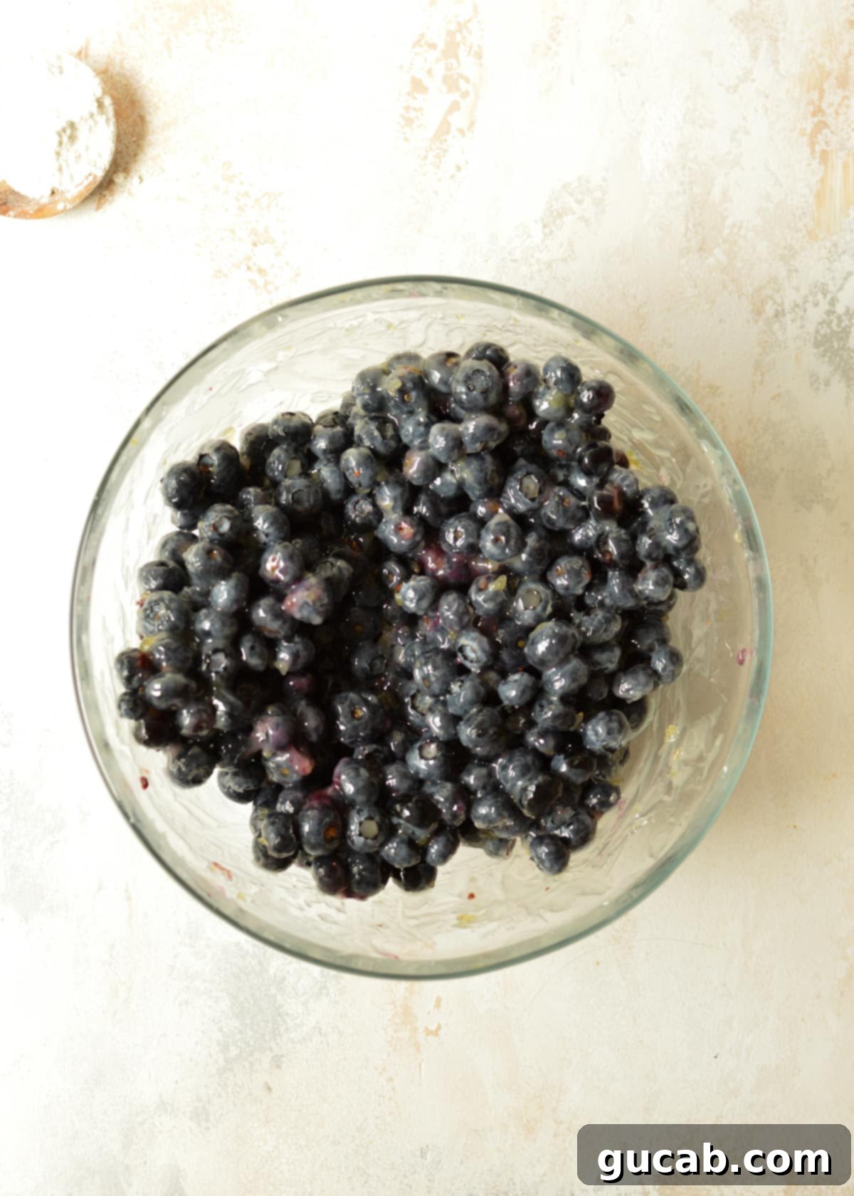 A bowl of fresh blueberries coated with the thick, clear cornstarch mixture for the pie filling.