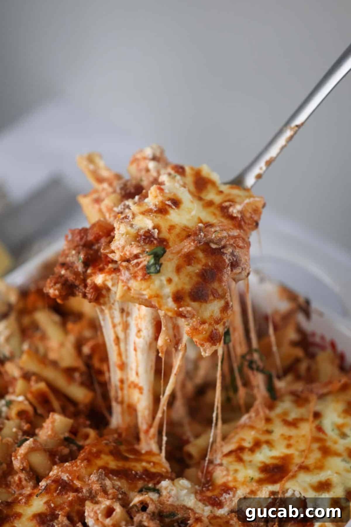 a spoonful of classic baked ziti with sausage and melted cheese