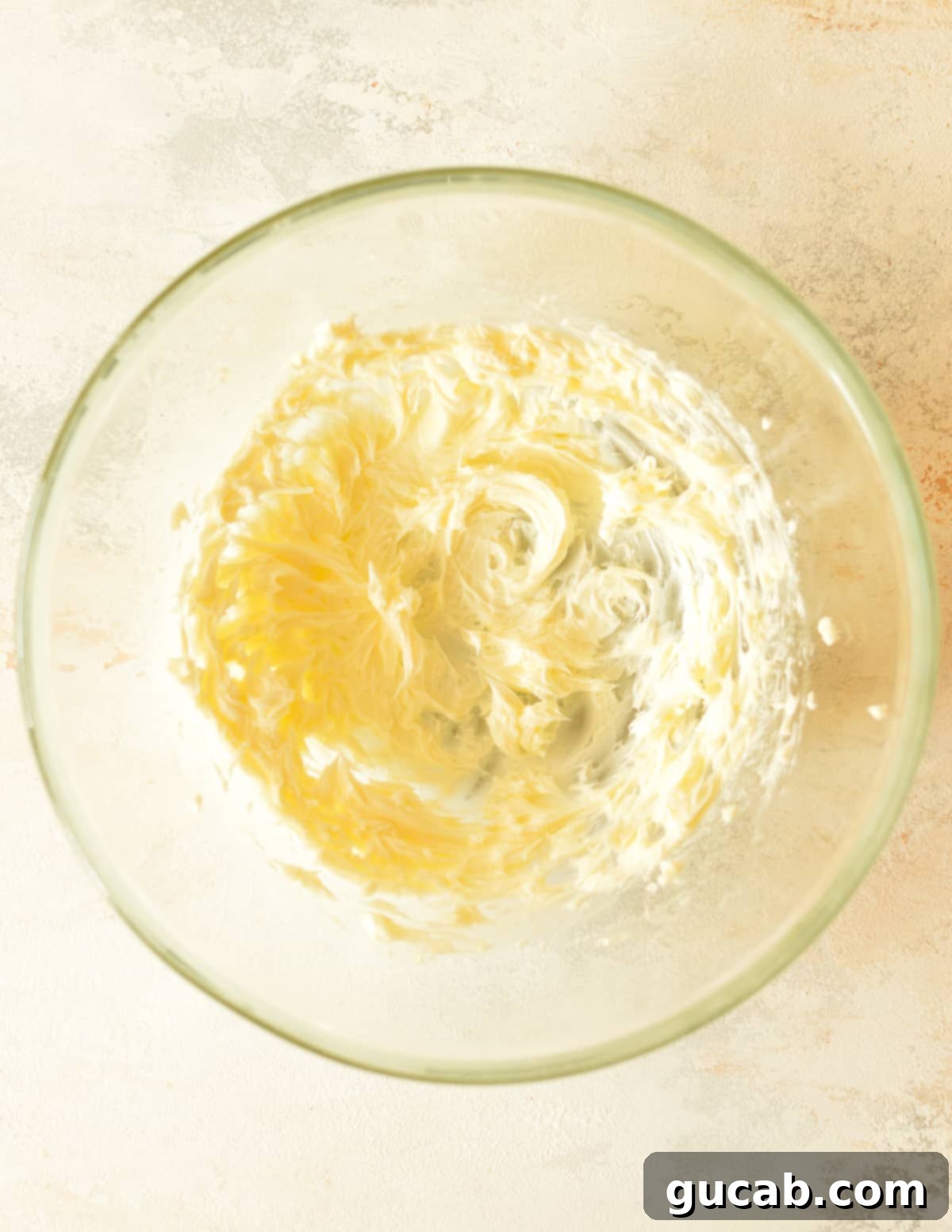 A mixing bowl filled with softened butter, creamed until light and fluffy, ready for the next ingredients.