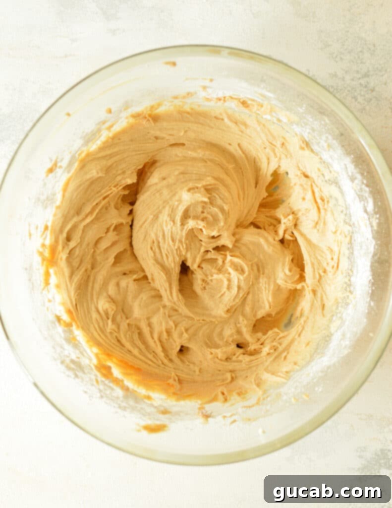 The fully mixed peanut butter cream cheese frosting, smooth and ready to be used.