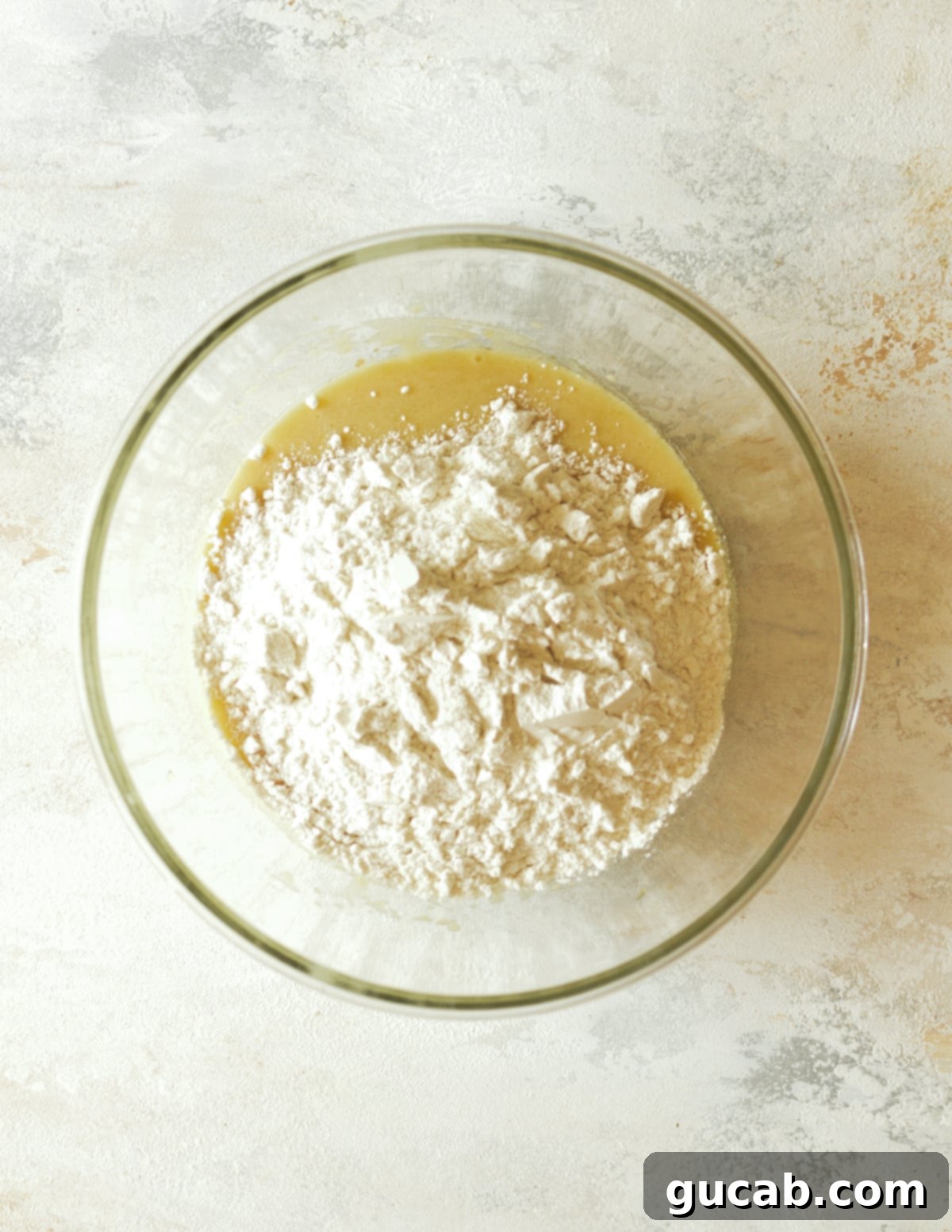a bowl of creamed oil and sugar with flour on top