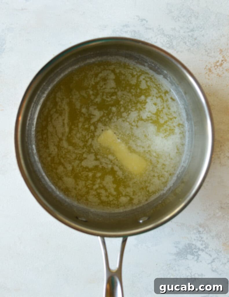 Butter melting gently in a large pot on the stovetop, ready for the next step in making protein rice crispy treats.