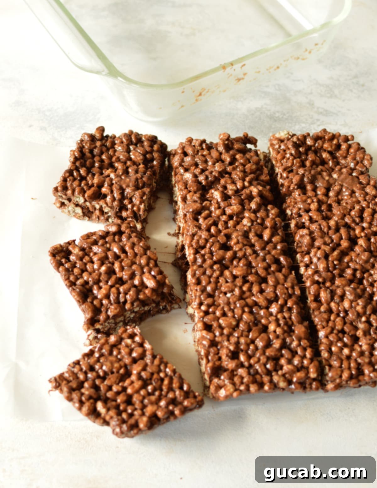 Fully cooled and sliced chocolate rice krispie treats laid out on a kitchen counter, ready to be enjoyed.