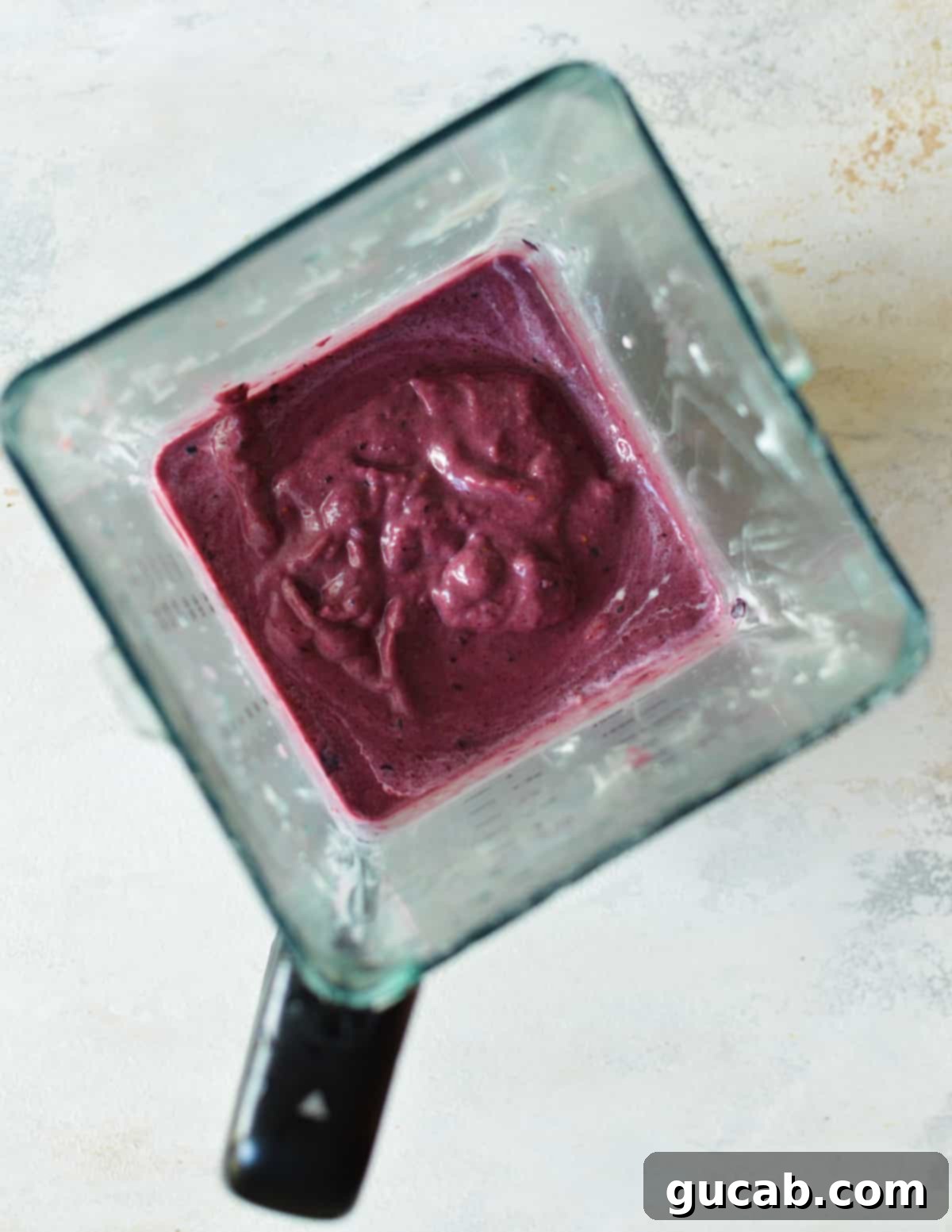a blender with mixed berry smoothie in it