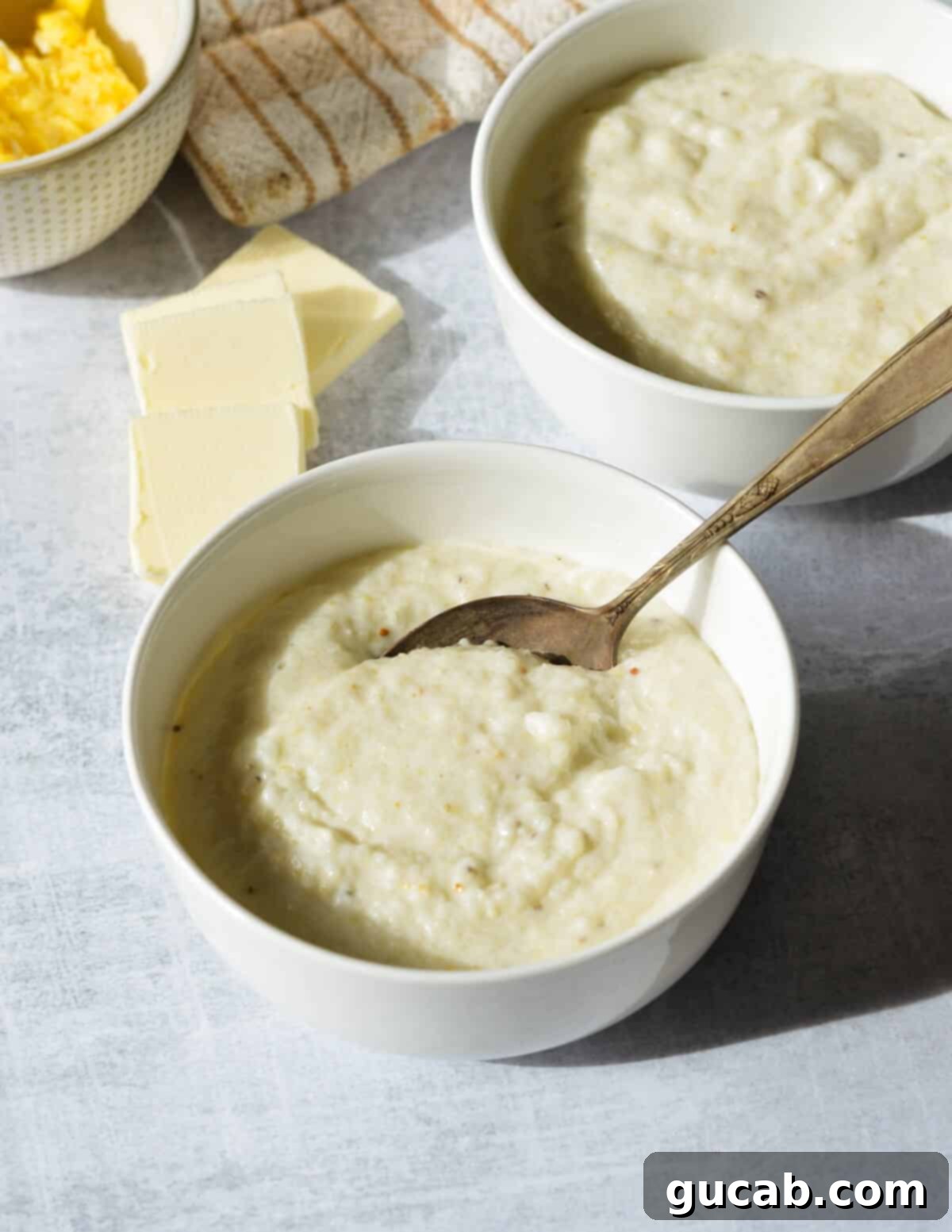 Hearty Creamy Grits 10 A bowl of creamy grits with a spoon, highlighting the delicious texture and comfort food appeal.