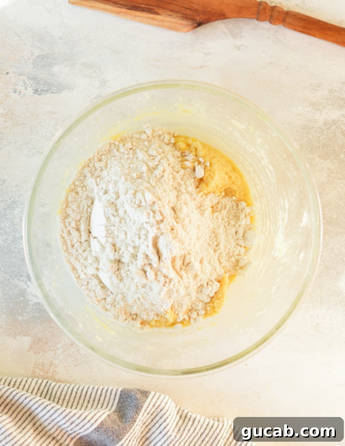 cookie dough in a mixer bowl with flour on top, ready for mixing