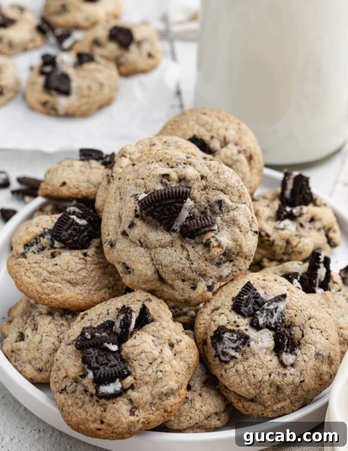 A perfectly arranged stack of delicious chocolate chip Oreo cookies on a white plate, showcasing their inviting texture and numerous chunky inclusions.