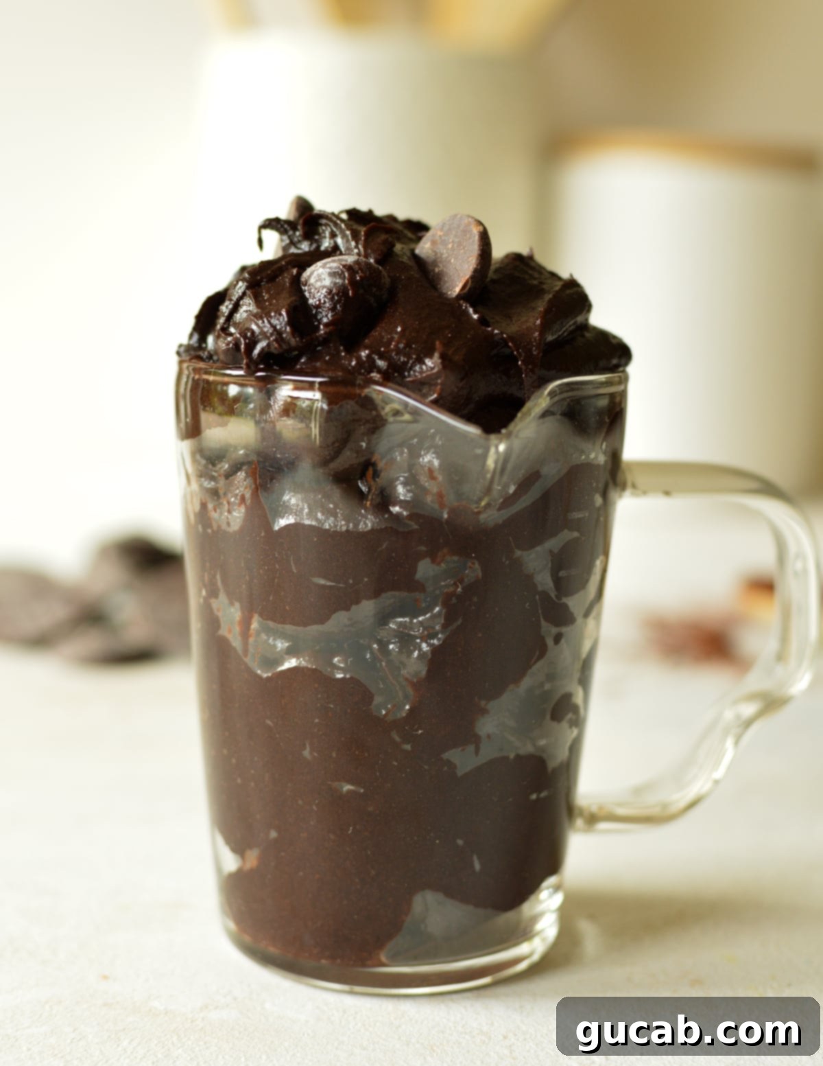 No-Bake Fudgy Brownie Indulgence 2 a glass of brownie batter, rich and fudgy, with a spoon for tasting
