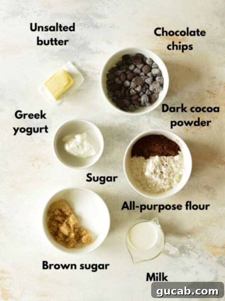 No-Bake Fudgy Brownie Indulgence 3 Collection of brownie batter ingredients laid out, including cocoa powder, flour, sugars, butter, milk, yogurt, and chocolate chips