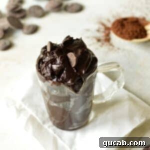 No-Bake Fudgy Brownie Indulgence 9 a glass of edible brownie batter ready to be eaten, with a spoon inside