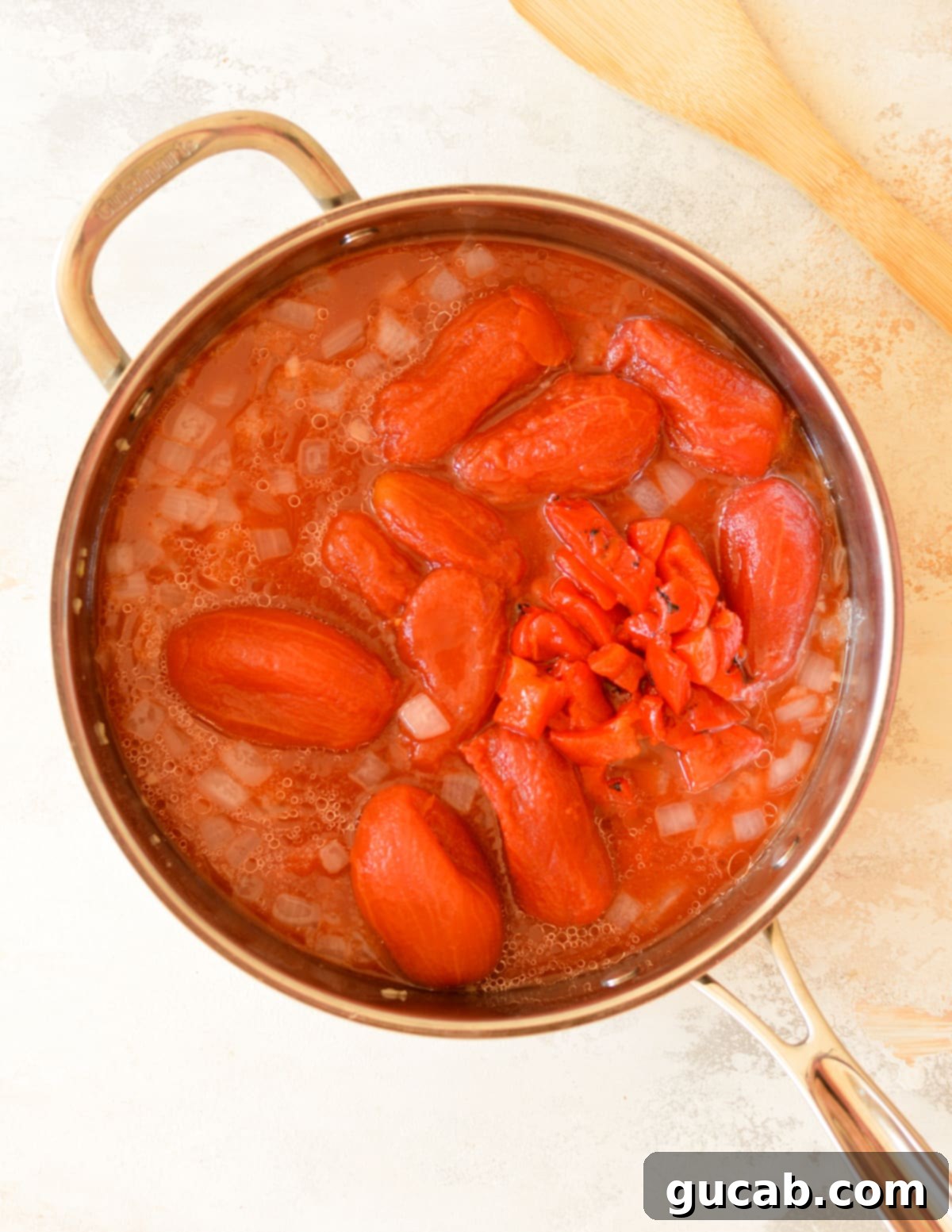 Rose Pasta 5 Whole peeled tomatoes and roasted red peppers added to the skillet with sautéed onions and garlic, beginning to simmer.