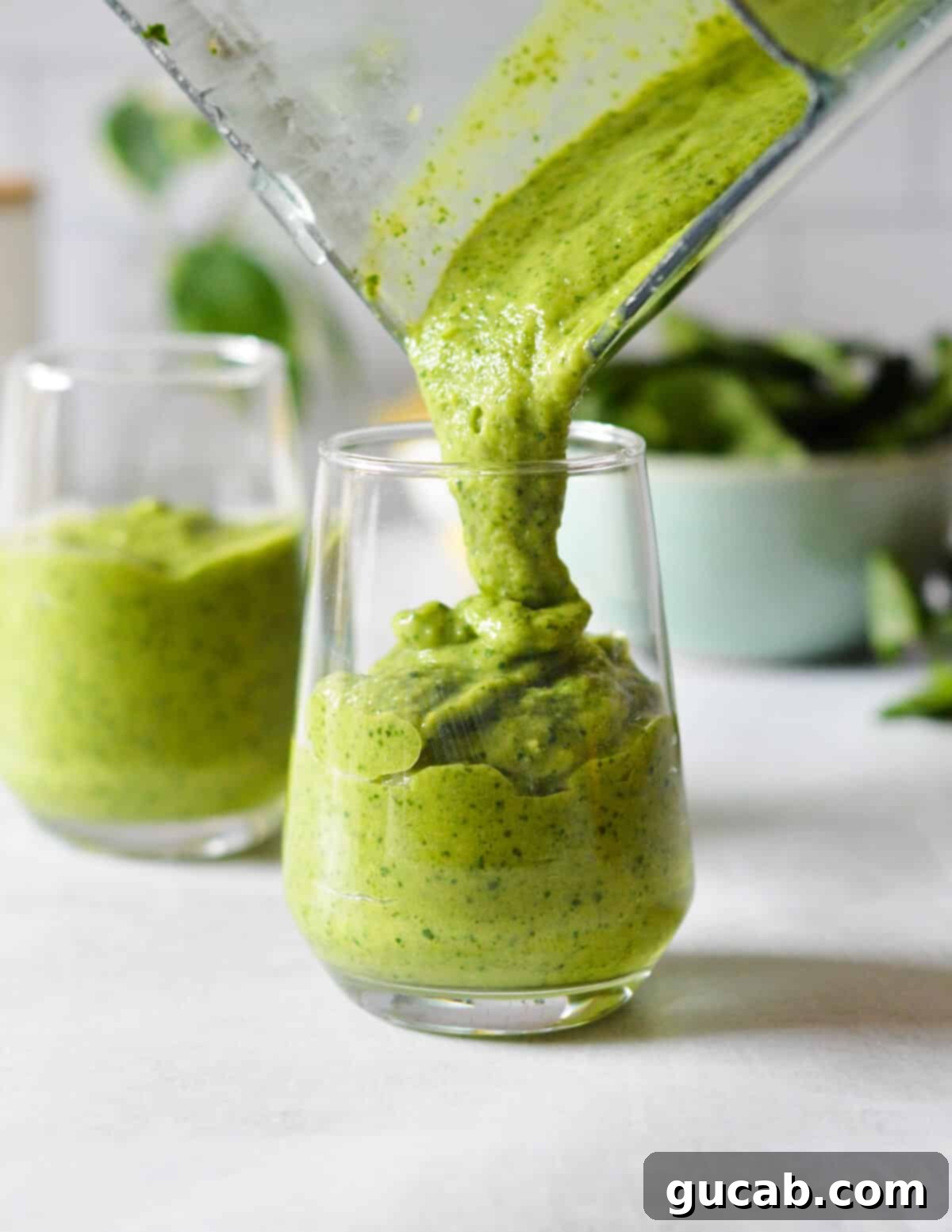 Island Iron Infusion 7 pouring a green smoothie into a glass.