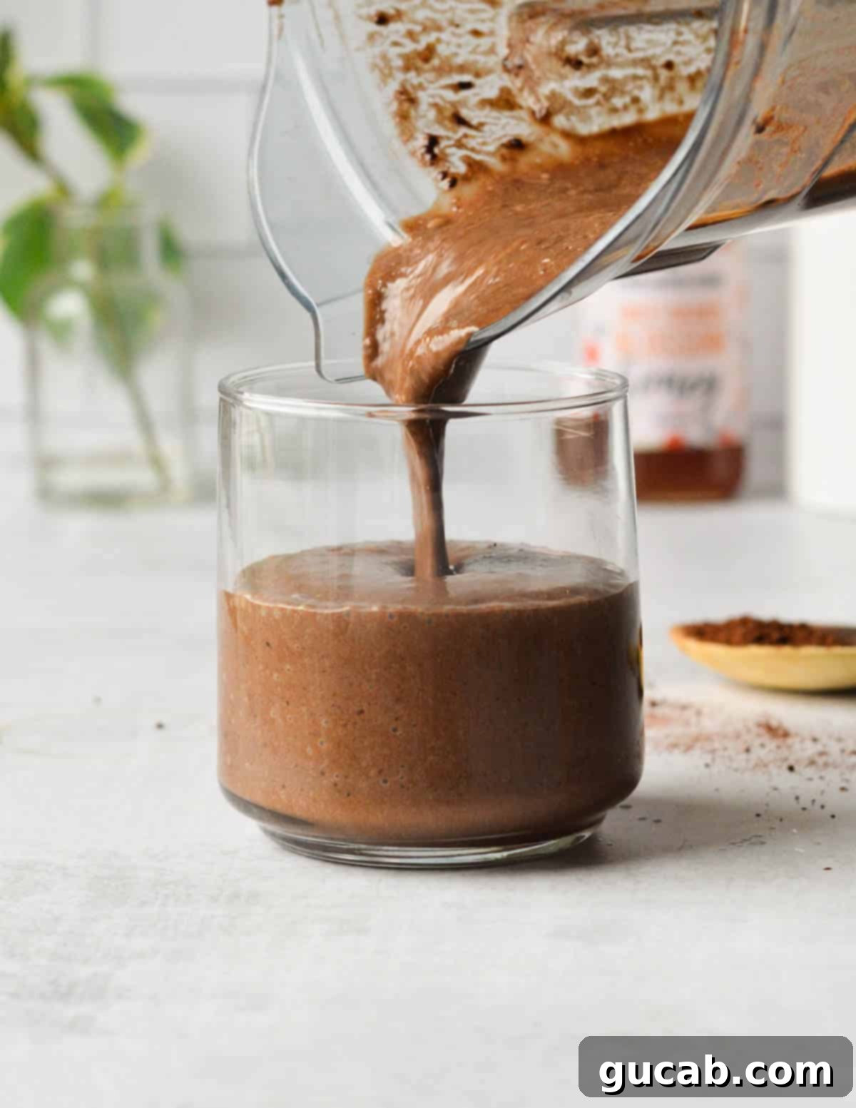 Decadent Chocolate Coffee Smoothie 7 pouring chocolate coffee smoothie into a glass.