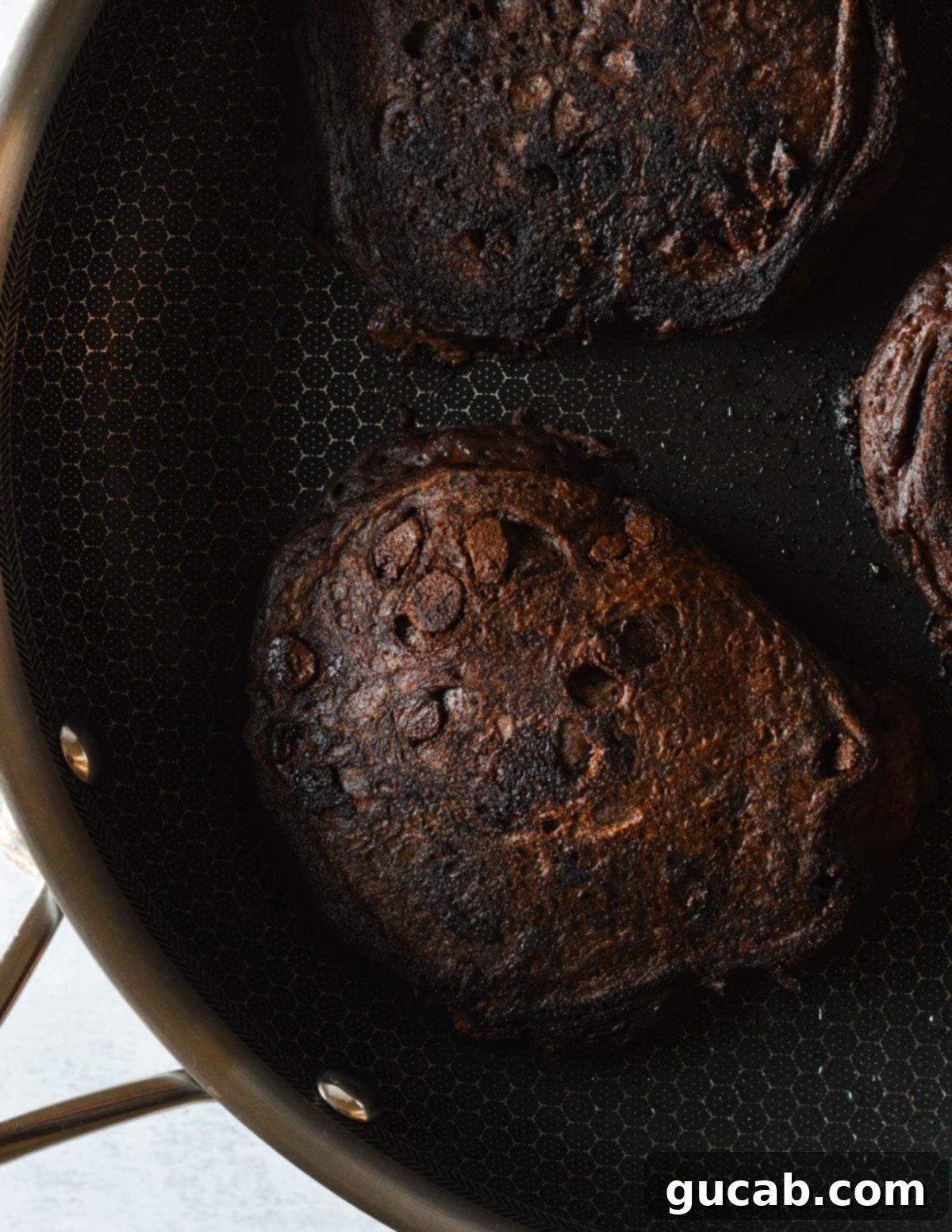 Guilt-Free Chocolate Pancake Indulgence 11 Double chocolate pancakes sizzling in a skillet, golden brown and almost ready to be flipped, demonstrating the perfect cooking stage.