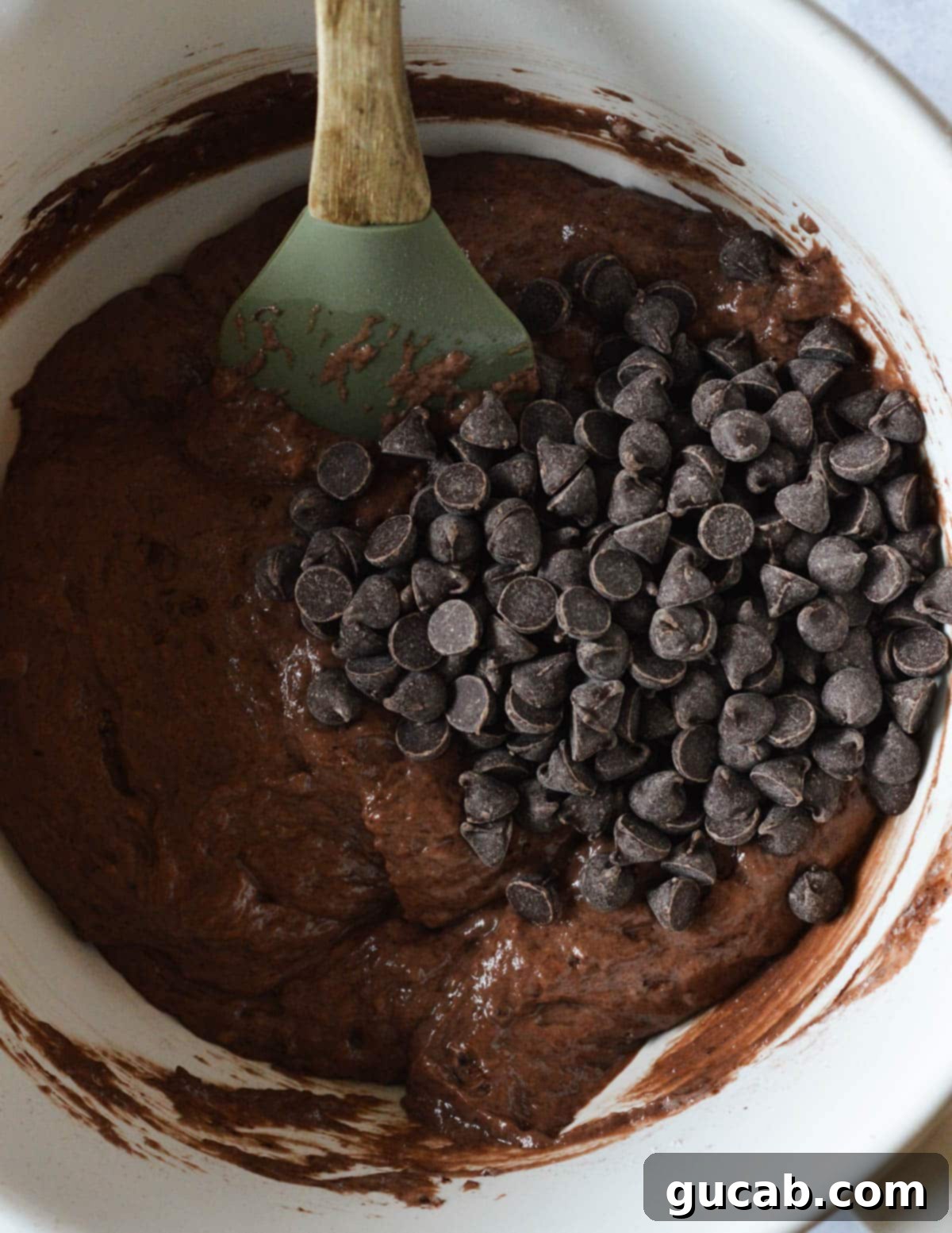 Guilt-Free Chocolate Pancake Indulgence 8 A bowl of gluten-free chocolate pancake batter generously topped with chocolate chips, poised for integration.