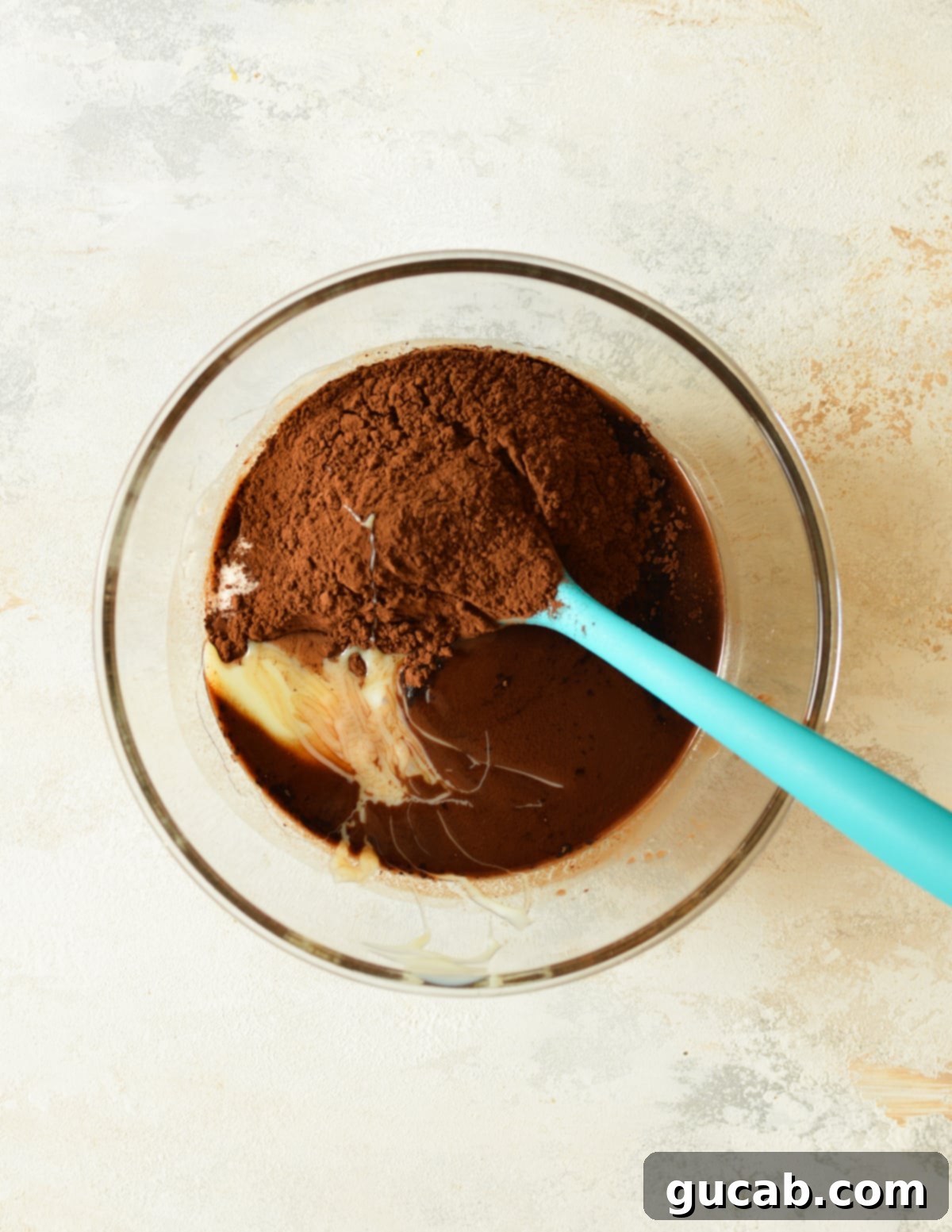 Fudgy Condensed Milk Brownies 5 A bowl of melted chocolate mixture with sweetened condensed milk and dark cocoa powder added.