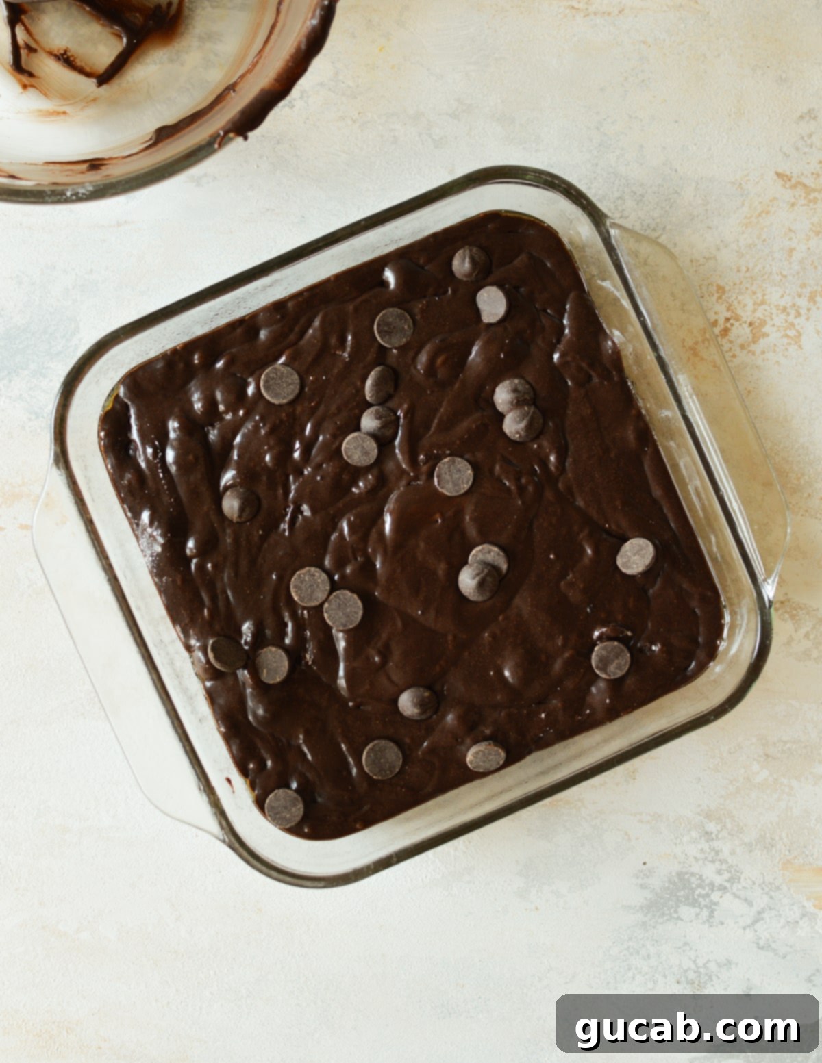 Fudgy Condensed Milk Brownies 7 Brownie batter poured into a square baking dish, ready for the oven.