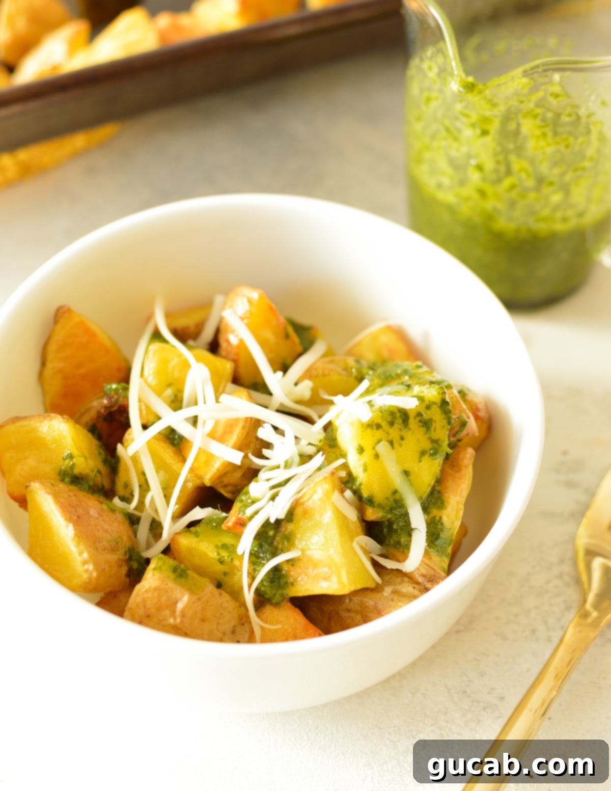 A bowl of roasted honey gold potatoes with cilantro vinaigrette and shredded Italian cheese, ready to be served.