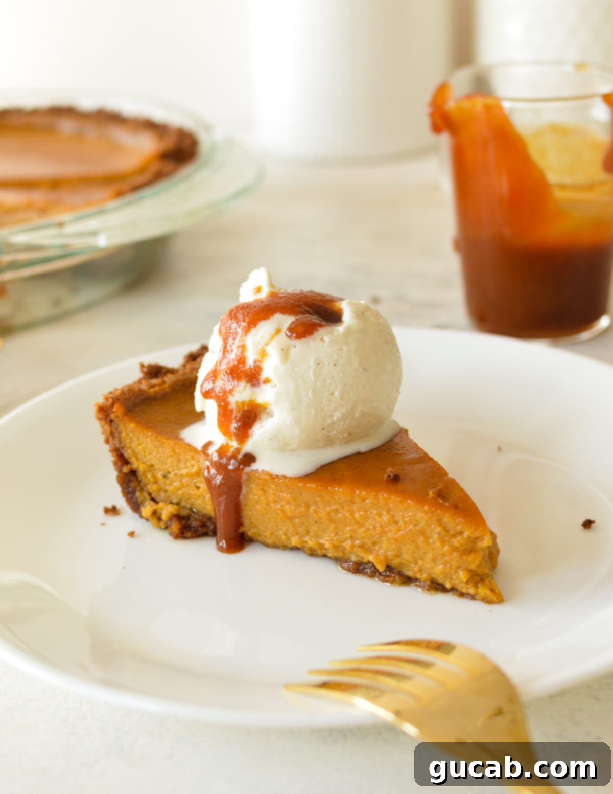 a slice of pumpkin pie with ice cream and caramel