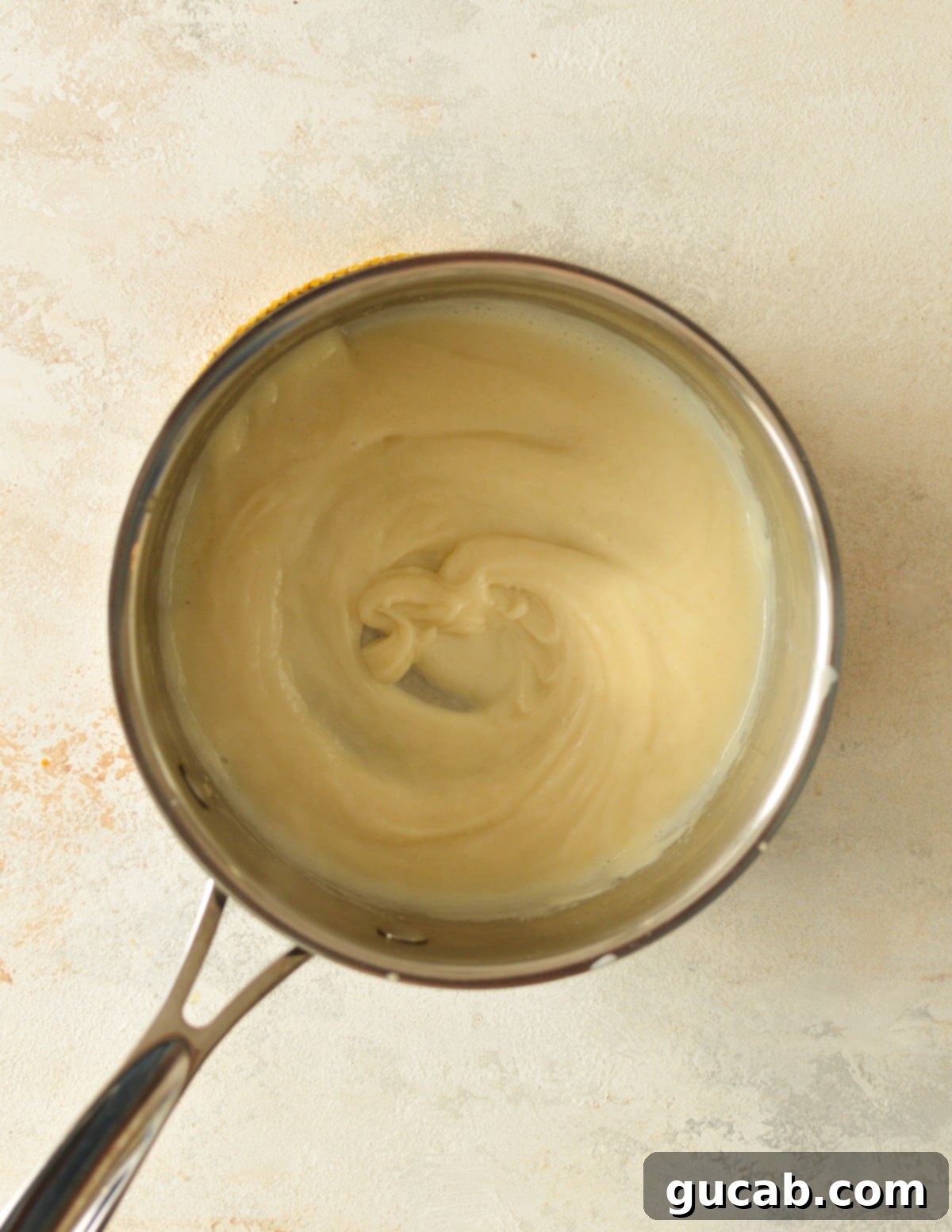 a gluten-free roux with milk being whisked in, starting to thicken