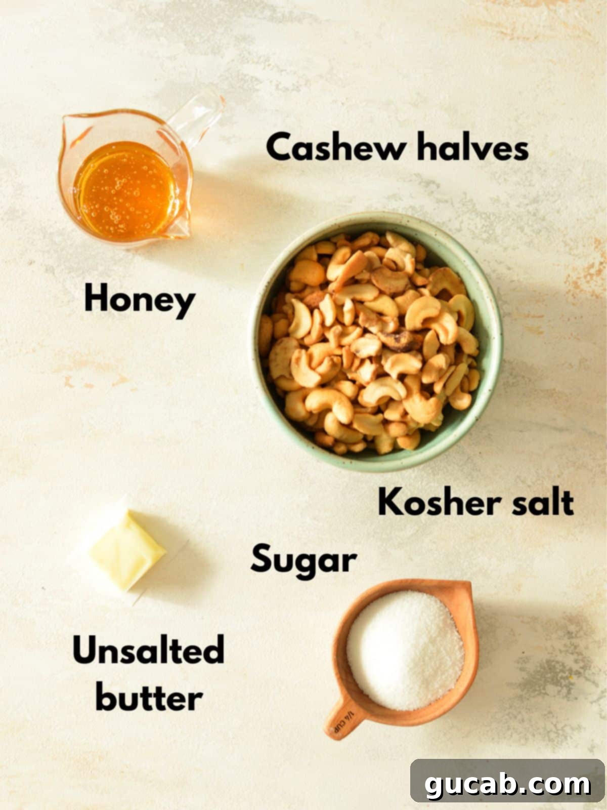 A flat lay photograph showcasing the simple ingredients needed for honey roasted cashews: cashews, honey, sugar, butter, and salt.