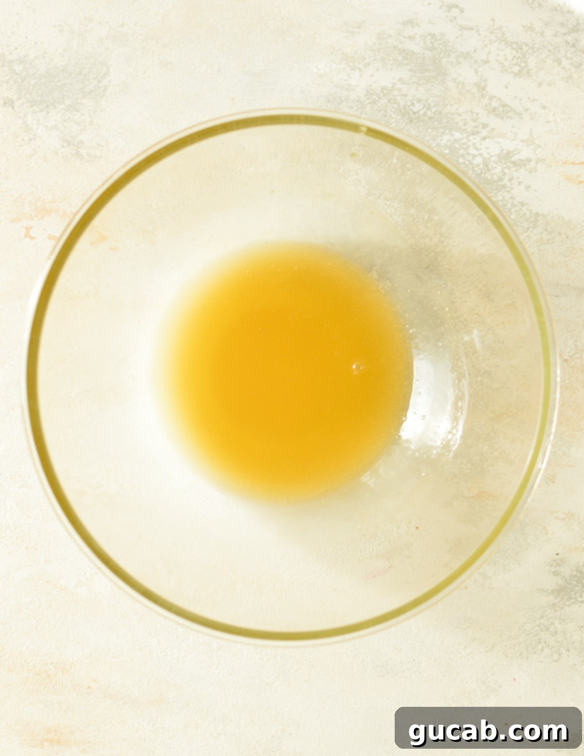 Melted honey and butter mixture in a bowl, stirred until smooth.