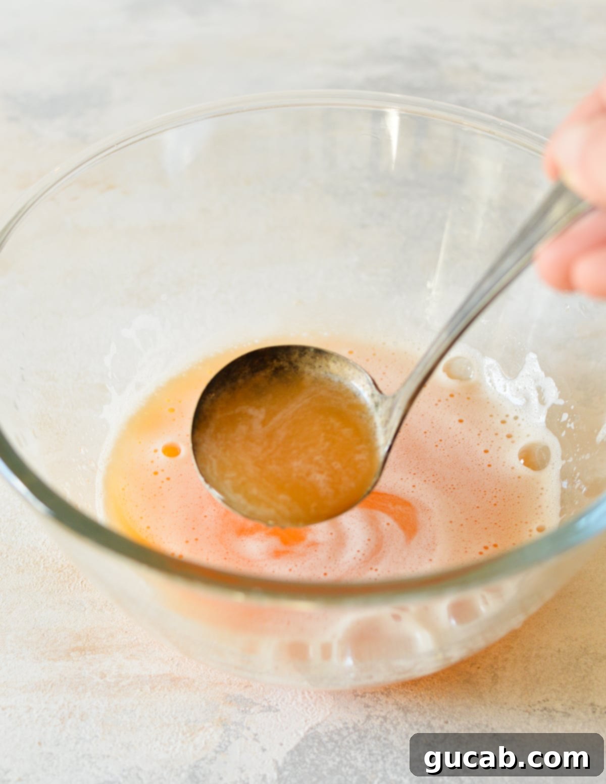 A bowl of freshly squeezed cantaloupe juice, clear and vibrant.