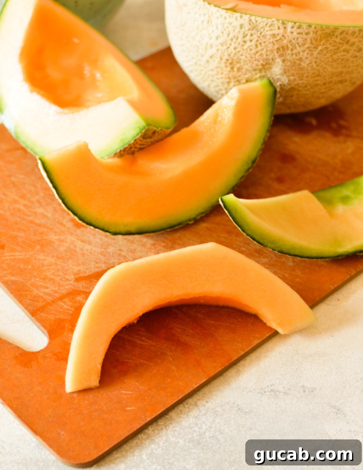 A single slice of cantaloupe with the rind separated.