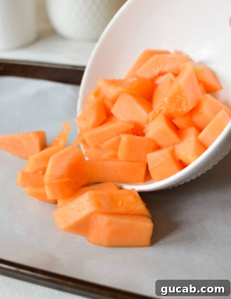 bowl pouring cantaloupe onto sheet pan.
