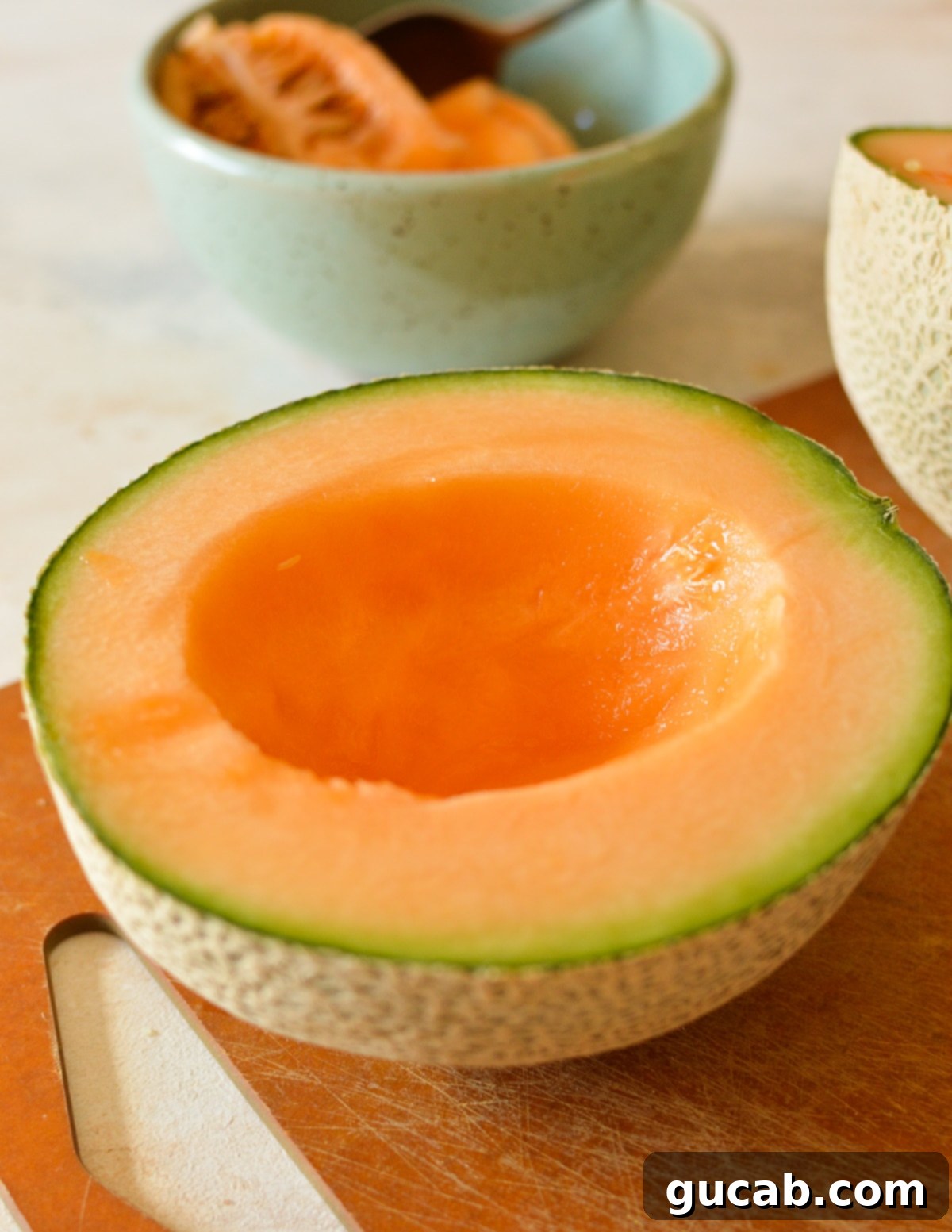 Two halves of a cantaloupe with the seeds scooped out.