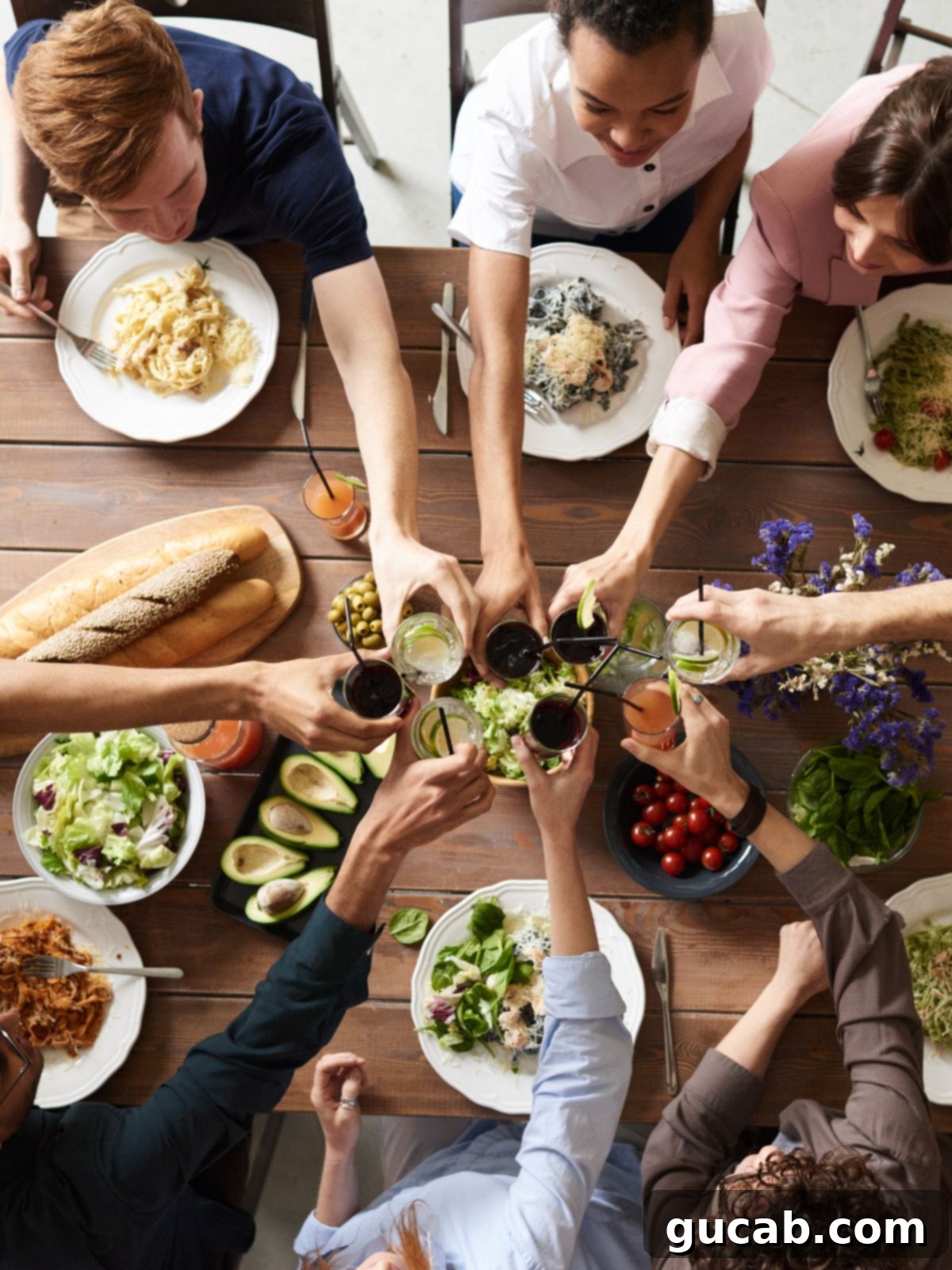 Budget-Friendly Feasts for a Crowd 2 A diverse group of people enjoying a communal meal together at a long table, laughing and sharing dishes.
