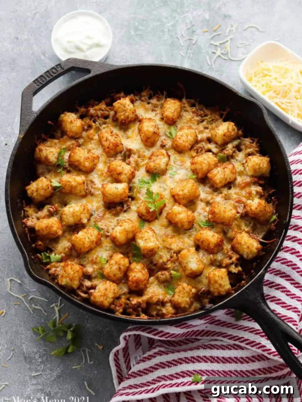 Budget-Friendly Feasts for a Crowd 13 A rustic skillet showcasing a golden-brown tater tot casserole, ready to be scooped and enjoyed.
