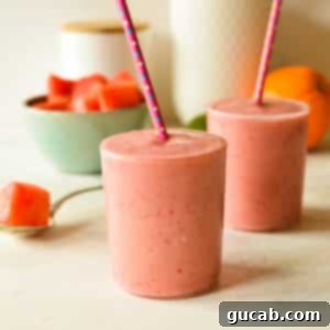Two vibrant watermelon banana smoothies with straws, presented in clear glasses.