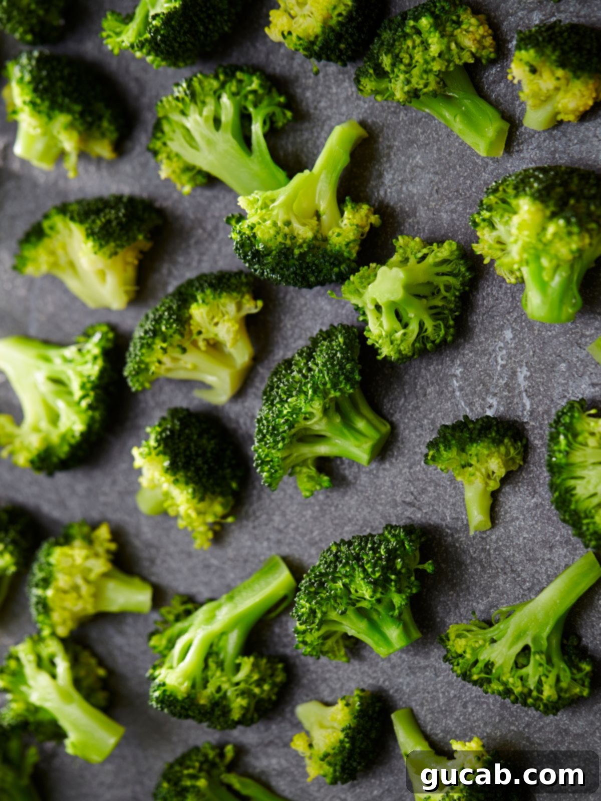 Cooked broccoli florets on a sheet pan, ready to be served or stored.