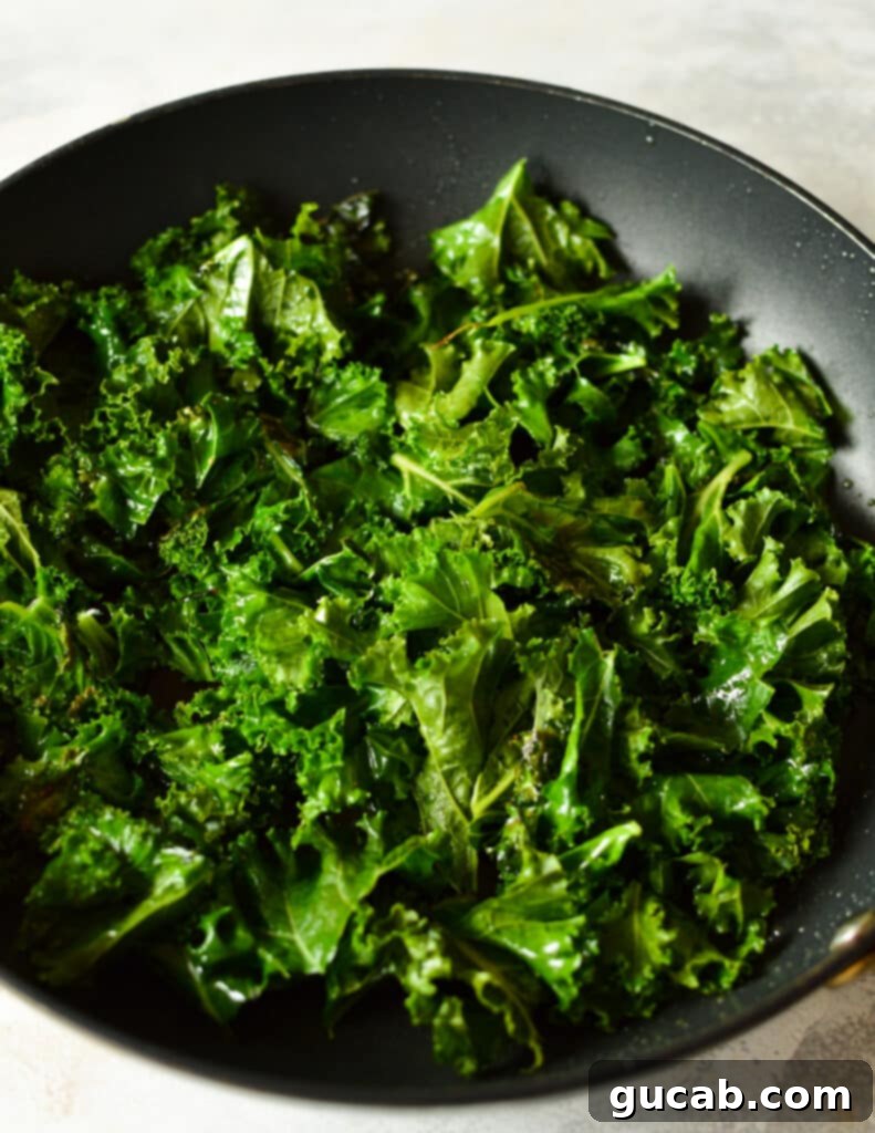 Kale wilting in a hot nonstick skillet with olive oil.