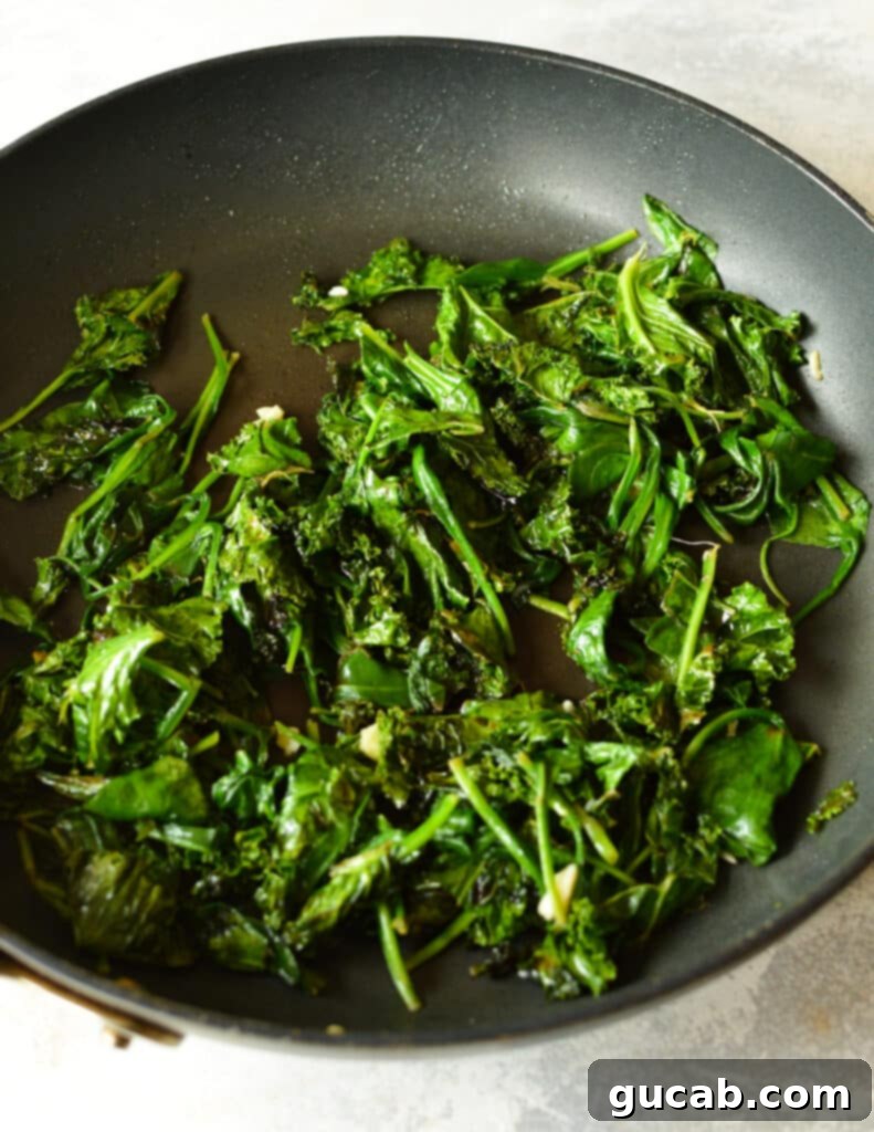 Finished sauteed spinach and kale in the skillet, vibrant and tender.