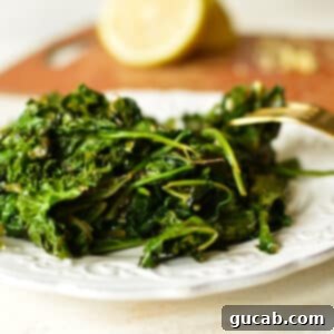 A plate of perfectly sauteed kale and spinach, garnished with fresh herbs.