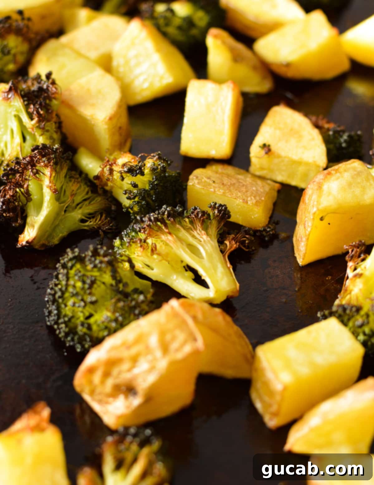 golden crispy roasted potatoes and broccoli on a sheet pan, freshly out of the oven.