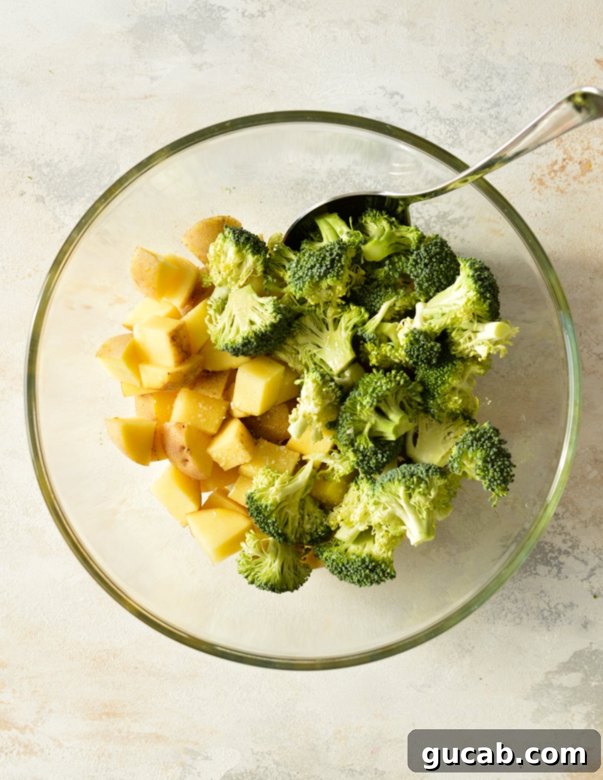 broccoli and potatoes in a bowl with a spoon. 